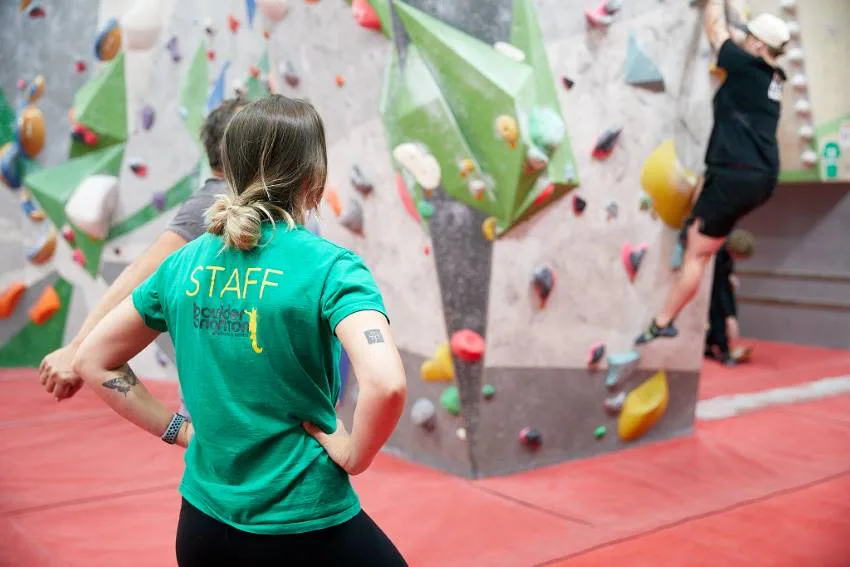 A member of staff watching over a climber on the wall
